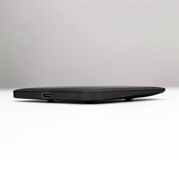 Side view of a closed black laptop with a visible usb port, placed on a flat surface against a white background.