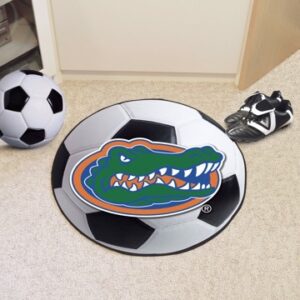 A round rug with the Florida Gators Soccer Mat logo, flanked by a soccer ball and a pair of cleats, on a carpeted floor.