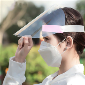 A woman wearing a face mask and an Economy Face Shield in an outdoor setting.