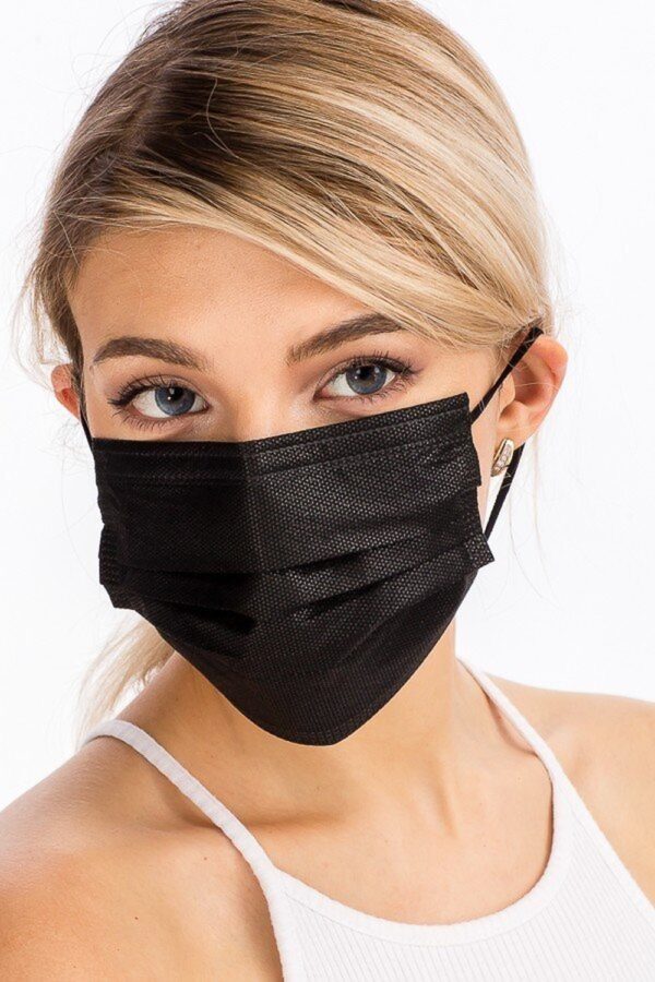 A young woman with blonde hair wearing a BLACK DISPOSABLE SURGICAL FACE MASK - 50 PACK and a white tank top, focusing her gaze towards the camera.
