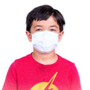 Young boy with short hair, wearing a red t-shirt and a Kids' Disposable 3-Ply Face Mask Pack of 50, smiling with his eyes, isolated on a white background.