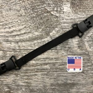 Adjustable black strap with plastic buckles on a wooden surface, featuring a "made in the usa" label with an american flag for the ELASTIC MASK CLIP EXTENDER 5/Pack.