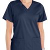 A woman wearing a navy blue Comfort Utility V-Neck Top (Liberty C13106) with two front pockets.