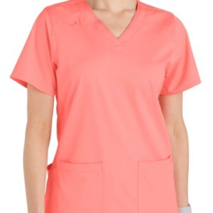 A woman in a bright coral pink Comfort Utility V-Neck Top (Liberty C13106) with two front pockets.