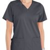 A woman wearing a Comfort Utility V-Neck Top (Liberty C13106) with a v-neck and two front pockets.