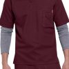 A man wearing a SOLID RIPSTOP SCRUB UTILITY TOP (Men's C15108) with a chest pocket and grey layered undershirt, paired with coordinating scrub pants.