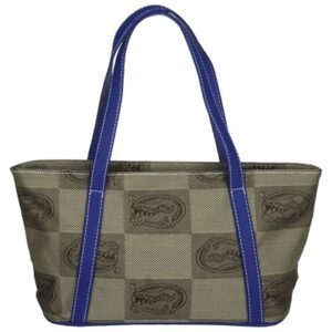 A beige Missy Handbag with a repeating skull pattern and contrasting blue handles and trim.