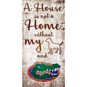 Decorative sign reading "University of Florida House is Not a Home" with illustrations of a dog and a colorful alligator on a rustic wood background.