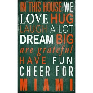 Decorative sign with inspirational phrases in white and red on a green background, including "love," "laugh a lot," and "cheer for miami.