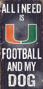Vintage-style sign reading "all i need is u football and my dog" with the university of miami logo.
