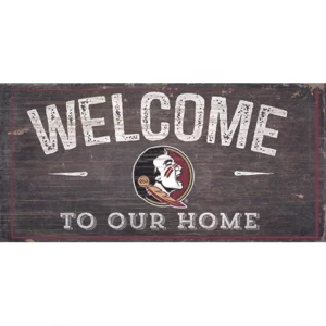 A worn wooden "welcome to our home" sign featuring a white stylized bird inside a burgundy circle.
