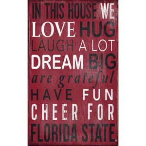 Decorative wall sign with the text "in this house we love hug laugh a lot dream big are grateful have fun cheer for florida state" on a red background.