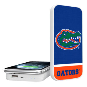 A Florida Gators Solid Wordmark 5000mAh Portable Wireless Charger with the university of florida gators logo on a blue background, displayed next to a smartphone.
