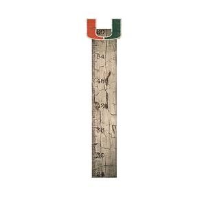 Vintage folding ruler with worn-out surface, extended and displaying numbers, topped with green and red marks.