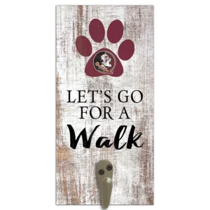 Wall-mounted key holder featuring the phrase "let's go for a walk" and a paw print with a sports team logo on a distressed wood background.