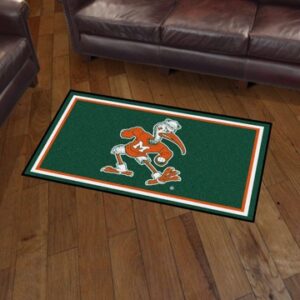 A rectangular University of Miami Hurricanes 3' x 5' Ultra Plush Rug with a green background, an orange and white clemson university tiger mascot, placed on a wooden floor near a leather sofa.