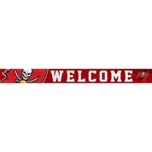 A red "welcome" sign featuring a pirate skull and crossed swords, with a football and the tampa bay buccaneers logo on the right end.