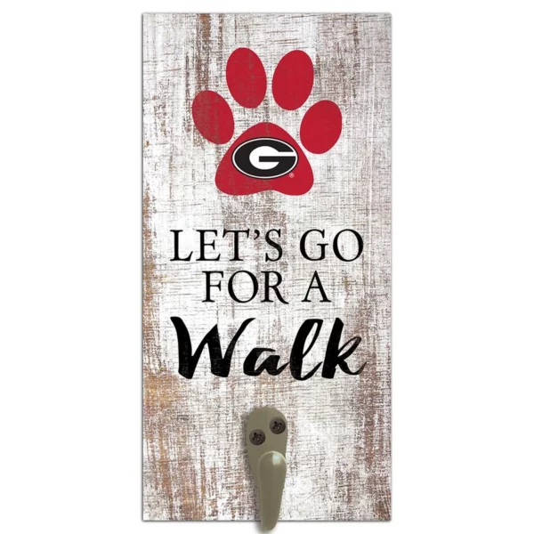 Decorative door sign featuring a red paw print with a "g" logo, the phrase "let's go for a walk" on a distressed wood background, and a metal hook.
