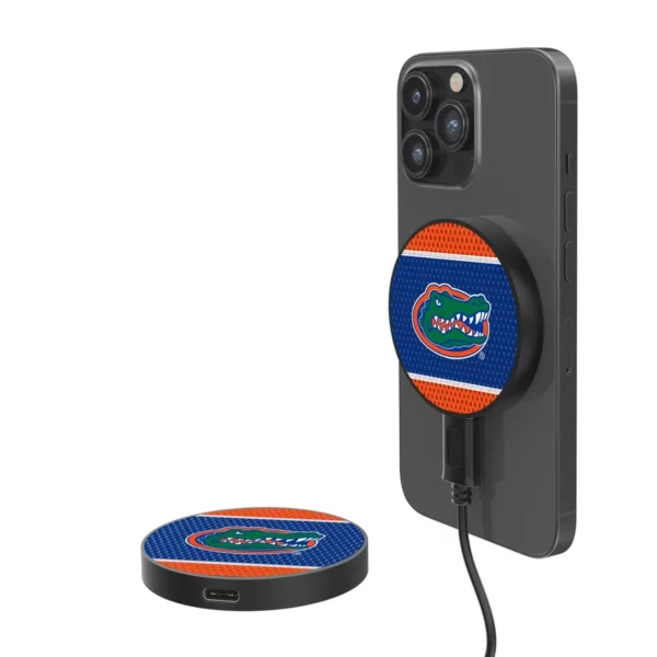 A smartphone with a FLORIDA GATORS MESH 10-WATT WIRELESS MAGNETIC CHARGER attached to its back, isolated on a white background.