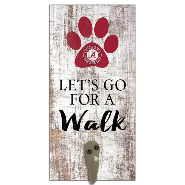 Wall-mounted leash holder with the phrase "let's go for a walk," a paw print, and a sports team logo on a distressed wood background.