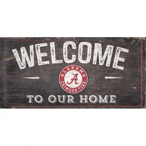 A vintage-style sign that reads "welcome to our home" with "alabama crimson tide" and the team’s logo on a distressed wooden background.