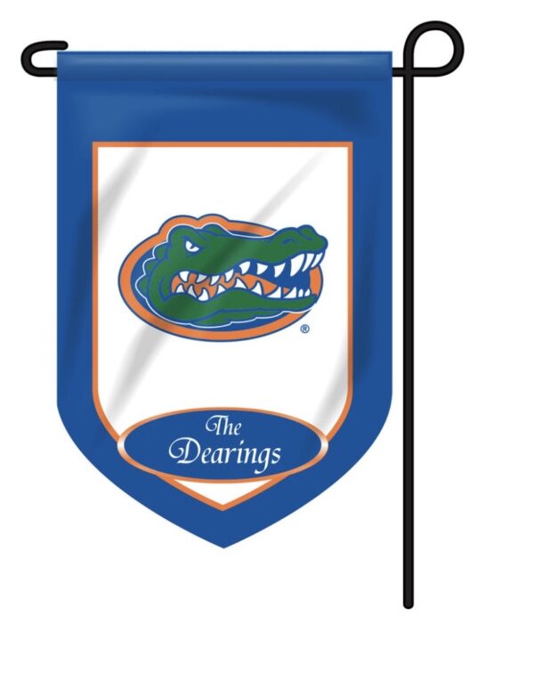 A Personalized Collegiate Garden Flag featuring a green and orange alligator emblem on a shield with the text "the dearings" below, hanging from a black metal pole.